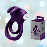 The VeDO Thunder Bunny Vibrating Cock Ring is displayed alongside its packaging on a softly blurred pastel background, emphasizing the VeDO brand's commitment to both style and pleasure.